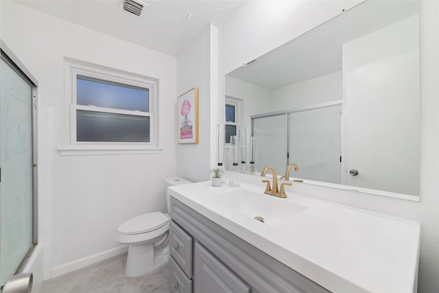 full bathroom with vanity, toilet, bath / shower combo with glass door, and a textured ceiling