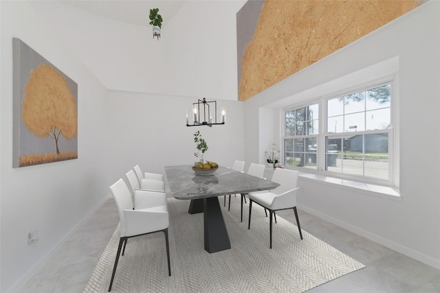 dining room with a high ceiling and an inviting chandelier