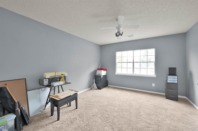 living area featuring carpet floors, a textured ceiling, and ceiling fan