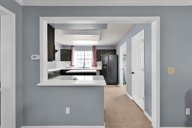 kitchen with kitchen peninsula, sink, black fridge with ice dispenser, and light tile patterned floors