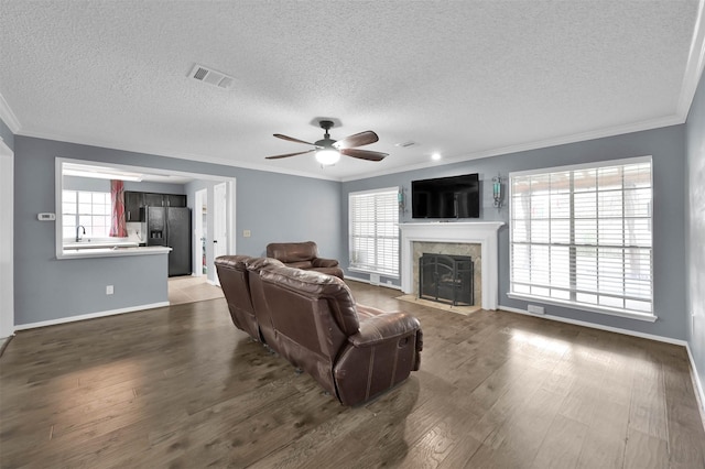 living room featuring crown molding, a textured ceiling, and dark hardwood / wood-style floors