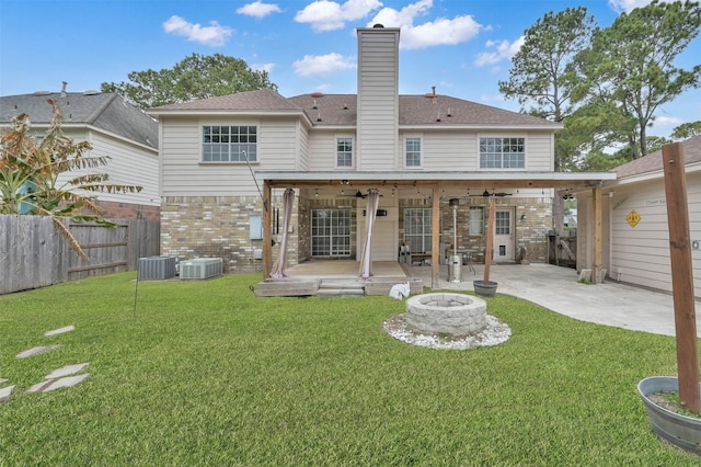 back of property featuring a fire pit, central AC, a lawn, and ceiling fan