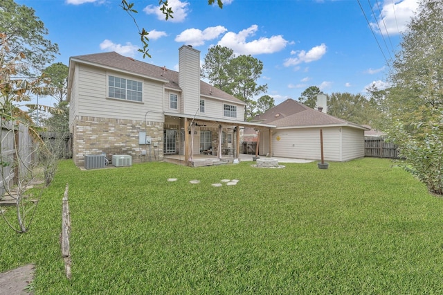 rear view of property with a lawn, a patio area, and central AC