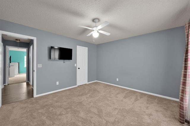 unfurnished bedroom featuring a closet, ceiling fan, carpet, and a textured ceiling