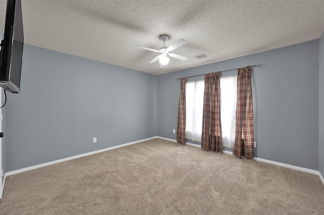 carpeted spare room with ceiling fan and a textured ceiling