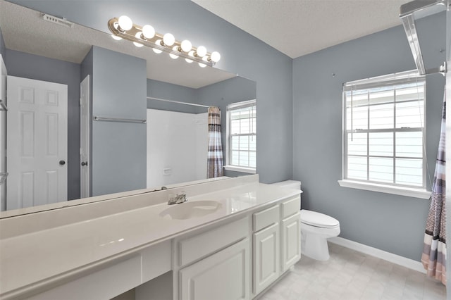 bathroom with vanity, toilet, curtained shower, and a textured ceiling