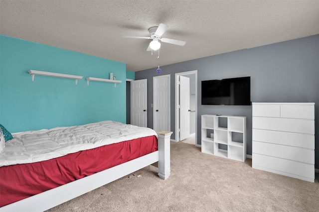 bedroom with ceiling fan, light colored carpet, and a textured ceiling