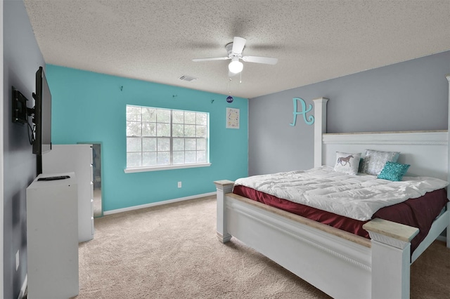 bedroom featuring ceiling fan, carpet, and a textured ceiling