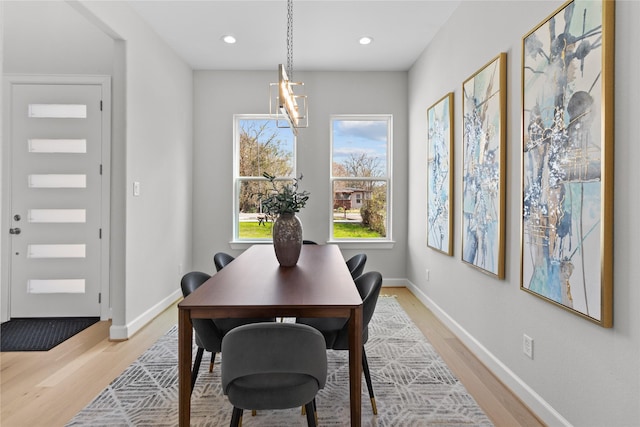 dining space with an inviting chandelier and light hardwood / wood-style floors