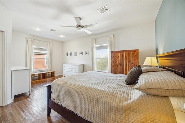 bedroom with ceiling fan, dark hardwood / wood-style floors, and multiple windows