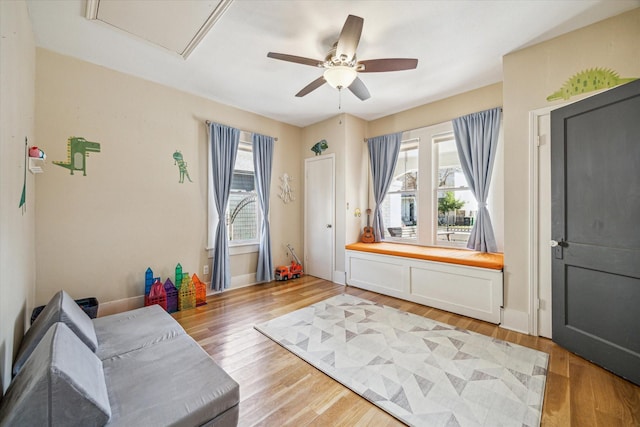 living area with ceiling fan and light wood-type flooring