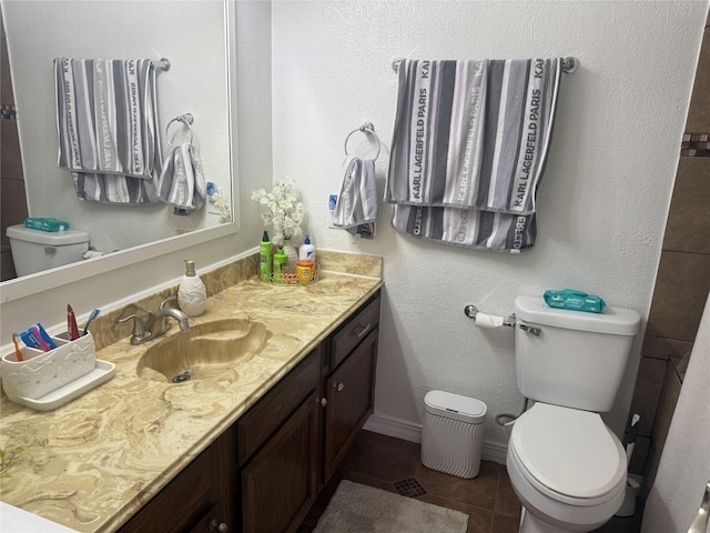 bathroom with toilet, vanity, and tile patterned flooring