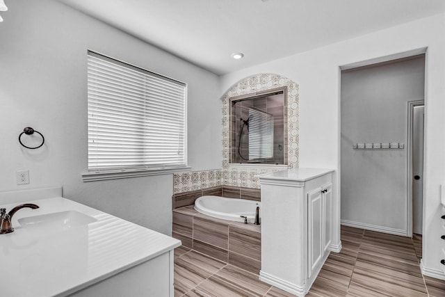 bathroom with sink, tiled bath, and tile patterned flooring