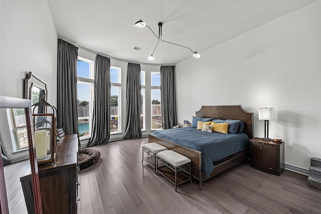 bedroom with dark wood-type flooring and multiple windows