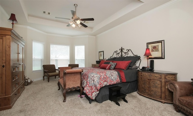 carpeted bedroom featuring ceiling fan, a tray ceiling, and ornamental molding