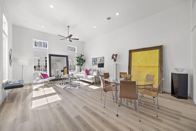 dining room featuring a high ceiling, french doors, ceiling fan, and light hardwood / wood-style flooring