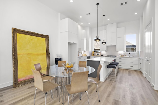 dining space with sink and light hardwood / wood-style floors