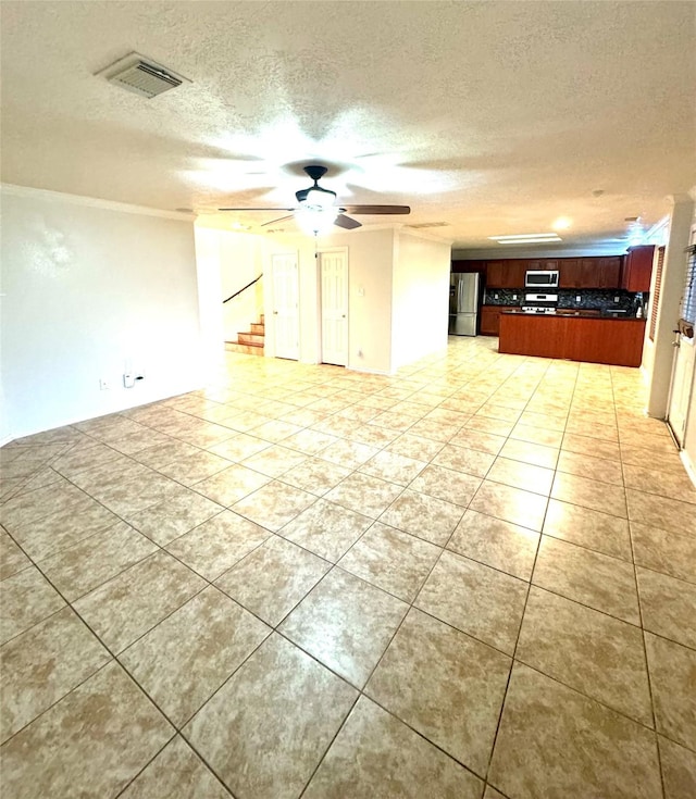 empty room featuring light tile patterned flooring, a textured ceiling, and ceiling fan