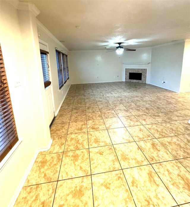 unfurnished living room with ceiling fan, ornamental molding, light tile patterned floors, and a tile fireplace