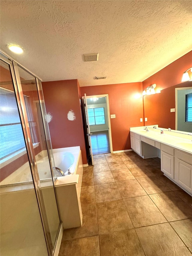 bathroom with a textured ceiling, tile patterned floors, vanity, and separate shower and tub