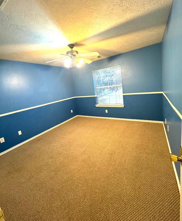 spare room featuring ceiling fan, a textured ceiling, and carpet