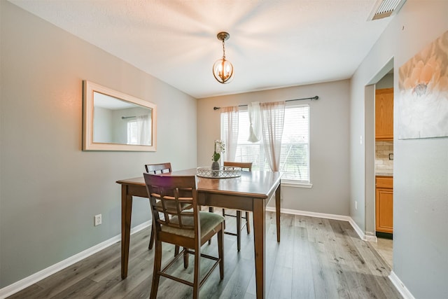 dining room with a chandelier and light hardwood / wood-style flooring