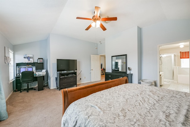 bedroom with light colored carpet, vaulted ceiling, ceiling fan, and ensuite bathroom