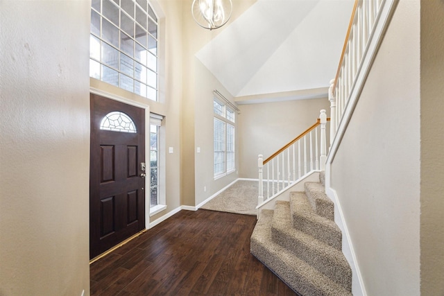 entrance foyer with dark hardwood / wood-style flooring, a chandelier, and high vaulted ceiling