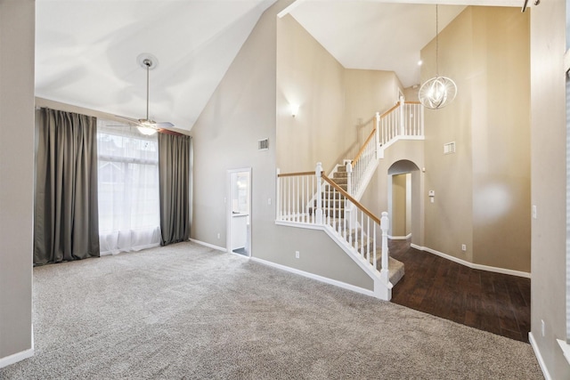 interior space with carpet, ceiling fan with notable chandelier, and high vaulted ceiling