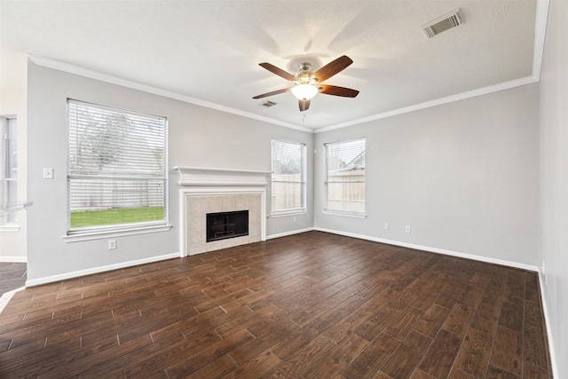 unfurnished living room featuring crown molding, ceiling fan, dark hardwood / wood-style floors, and a tile fireplace