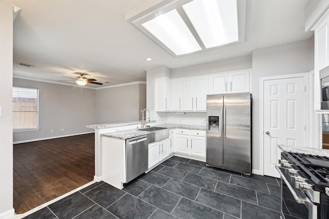 kitchen featuring sink, kitchen peninsula, ceiling fan, stainless steel appliances, and white cabinets