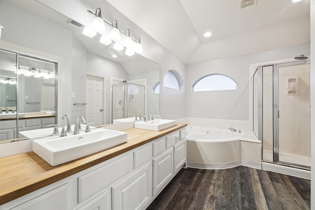 bathroom featuring hardwood / wood-style flooring, lofted ceiling, plus walk in shower, and vanity