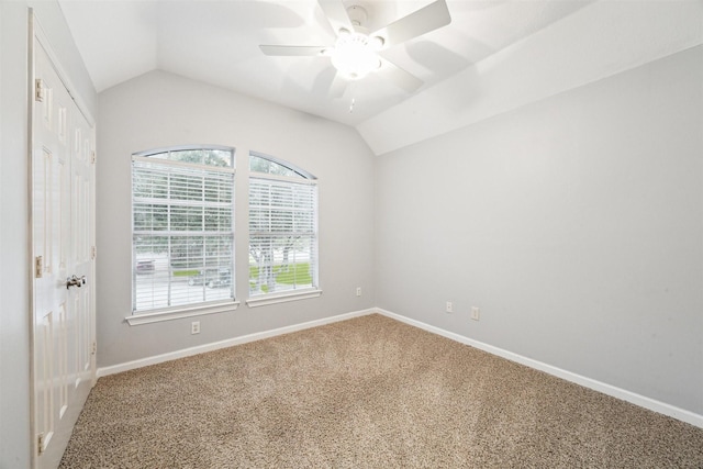 carpeted spare room featuring ceiling fan and vaulted ceiling