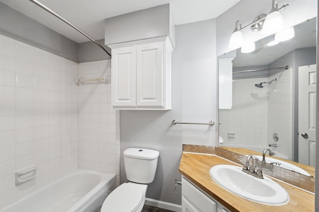 full bathroom with tiled shower / bath, vanity, and toilet