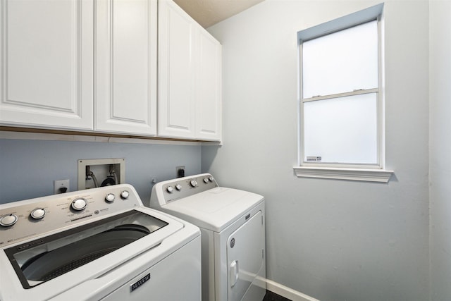 washroom featuring cabinets and separate washer and dryer