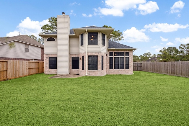 rear view of house with a sunroom and a lawn