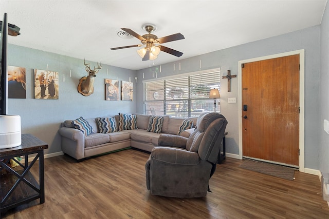 living room featuring ceiling fan and dark wood-type flooring