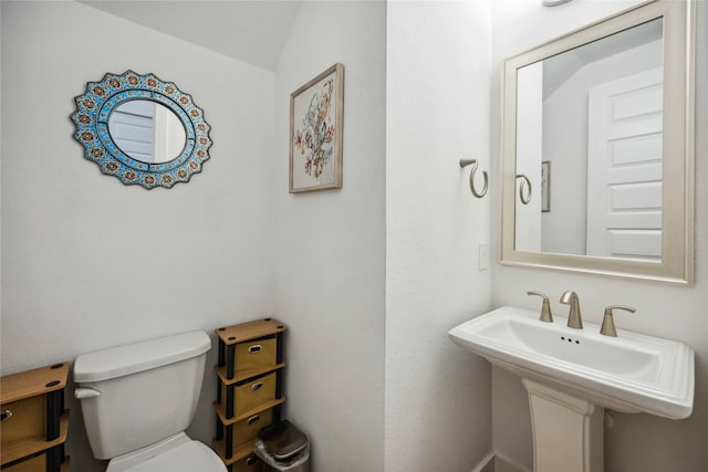 bathroom featuring lofted ceiling, sink, and toilet