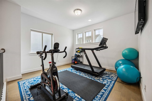 workout room with baseboards and wood finished floors