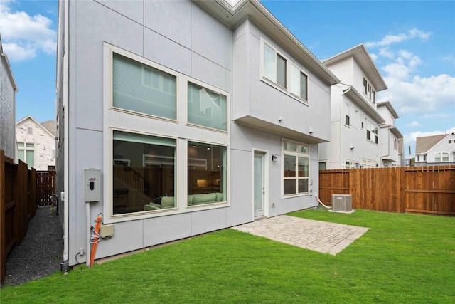 back of property featuring stucco siding, a fenced backyard, cooling unit, and a yard