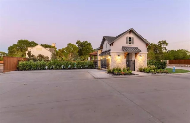 view of front of property featuring a gate, fence, concrete driveway, and stucco siding