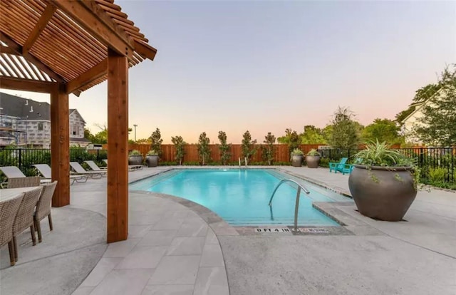 community pool with a fenced backyard and a patio