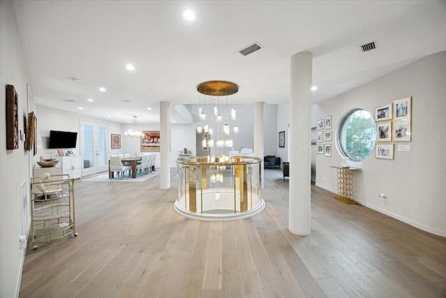 interior space with light wood-type flooring and an inviting chandelier