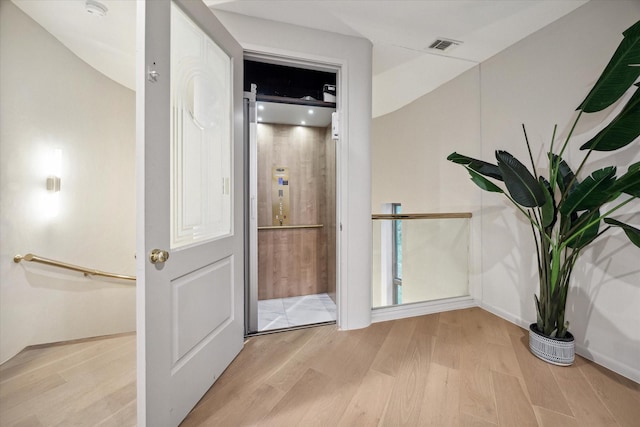 interior space with elevator and wood-type flooring