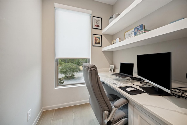 office featuring built in desk and light hardwood / wood-style flooring