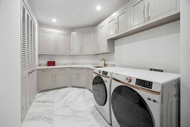 washroom featuring sink, cabinets, and washer and dryer