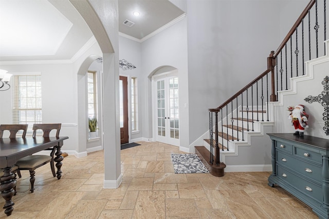 foyer entrance featuring french doors, a chandelier, and ornamental molding