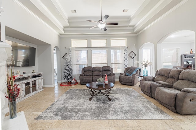 living room with a towering ceiling, a raised ceiling, ornamental molding, and light tile patterned flooring