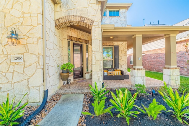 entrance to property featuring stone siding and covered porch