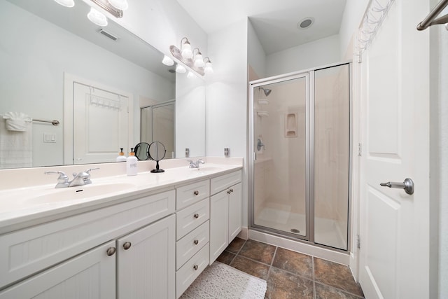 bathroom with a shower with shower door and vanity